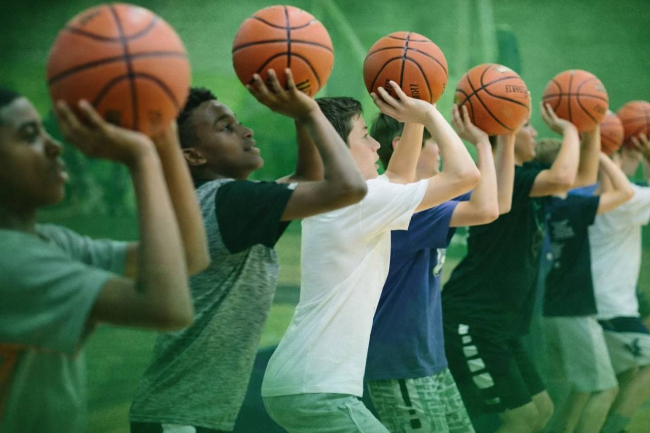 Youth basketball athlete receiving instruction from a trainer