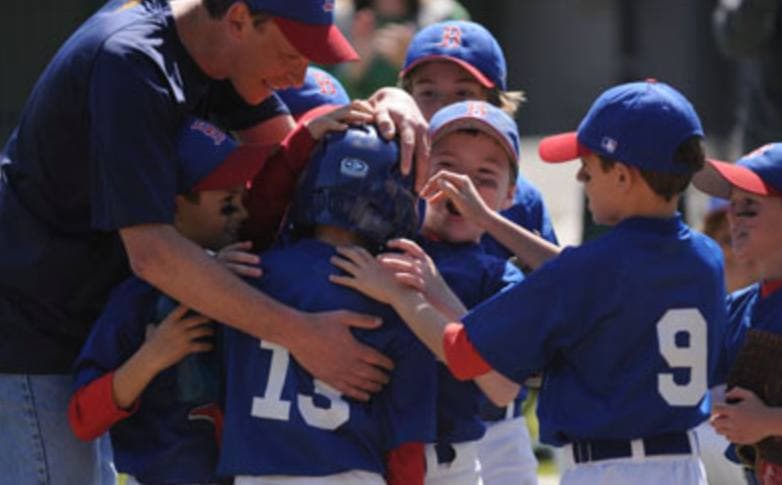 Baseball coach working one-on-one with a young athlete